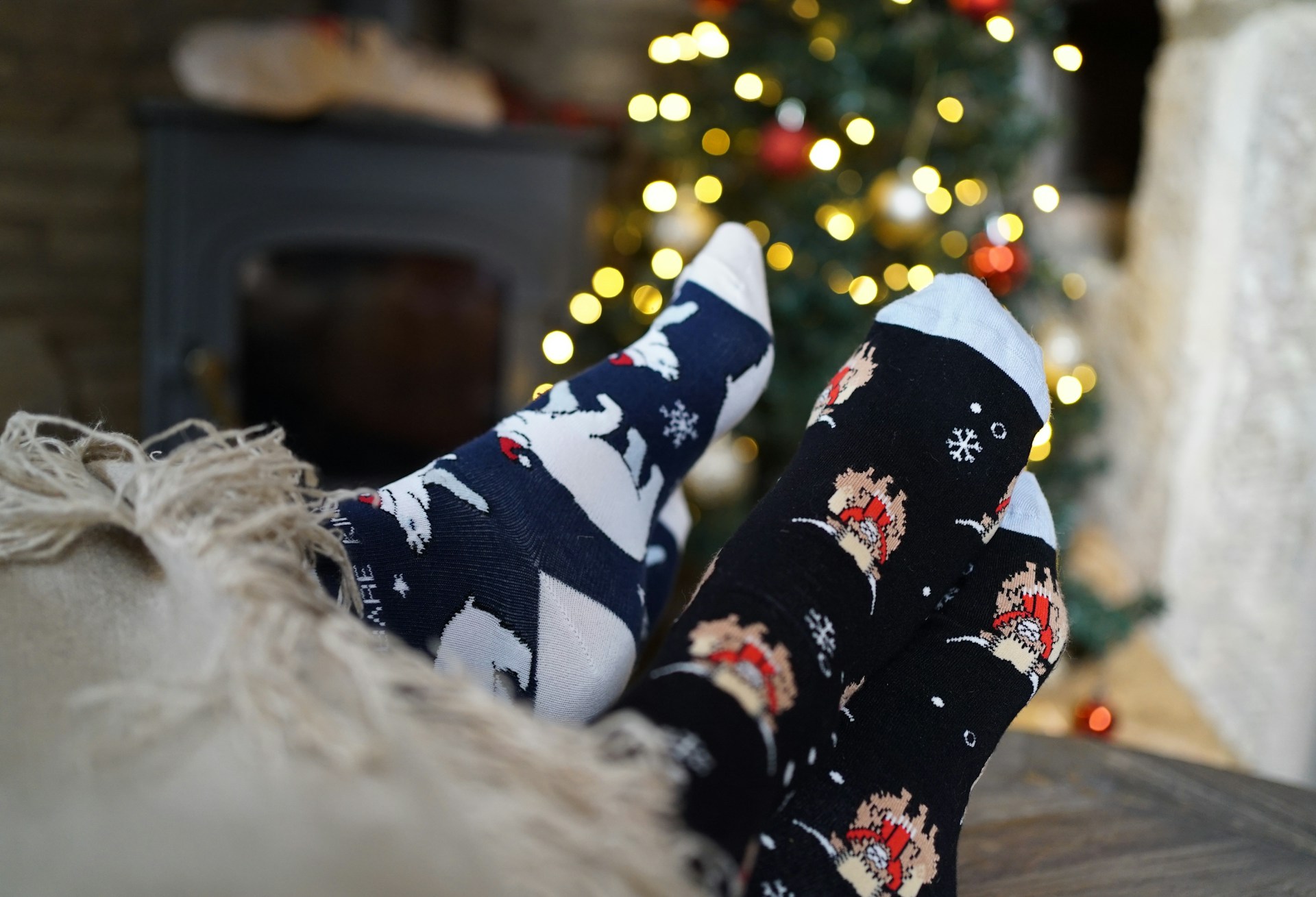 Calcetines navideños frente a la chimenea y árbol de navidad